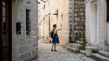 年轻时髦的旅行女孩在黑山旅行，并寻找佩拉斯<strong>地标</strong>。 有<strong>地图</strong>的漂亮女游客